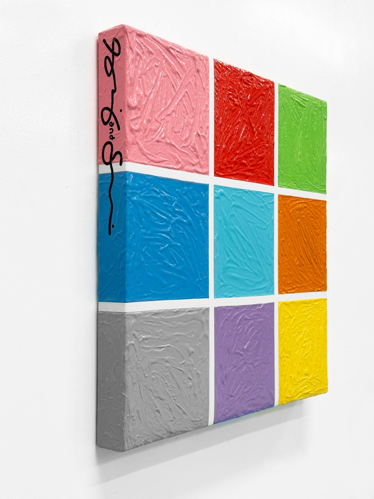 Colorful square block with textured surface on a white background