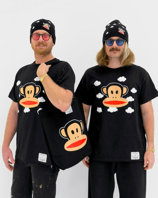 Two men wearing black t-shirts with a cartoon monkey design, holding a matching black bag.